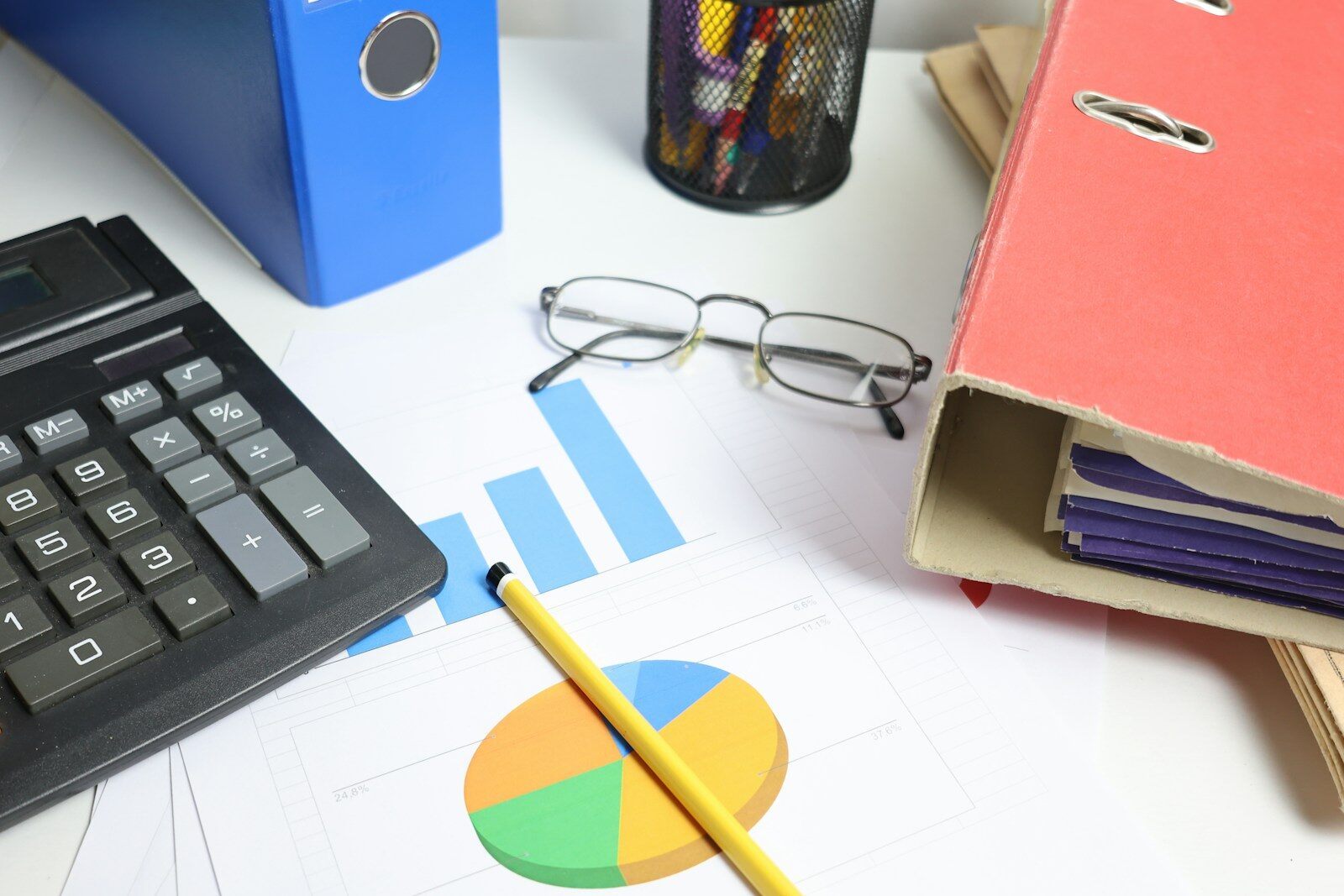 Desk with calculator, charts, and binders